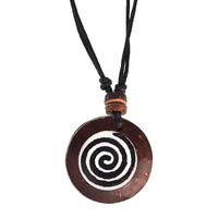 Load image into Gallery viewer, A round brown wooden pendant with a black and white spiral design hangs from an adjustable black cord, accented by two small brown beads—a classic Surferkette Haifzahn Surfbrett rund Holz Muschel look.

