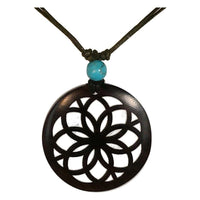 Load image into Gallery viewer, The Holzkette Türkis features a filigran round black Holzanhänger with a flower-like cutout and a turquoise bead, strung on a verstellbare Baumwollkette – ideal as Unisex Schmuck.
