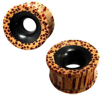 Load image into Gallery viewer, Two cylindrical Flesh ribbed Tunnel Eisenholz Kokosholz schwarz braun ear gauges with woodgrain and leopard print patterns and black centers, displayed from different angles on a white background.
