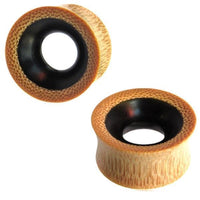Cargar imagen en el visor de la galería, Two hand-carved Tunnel Eisenholz Bambusholz ear gauges in black and light brown with dotted grain pattern, featuring a wide tunnel shape; ideal as stylish, unisex Tribal Holztunnel plugs.
