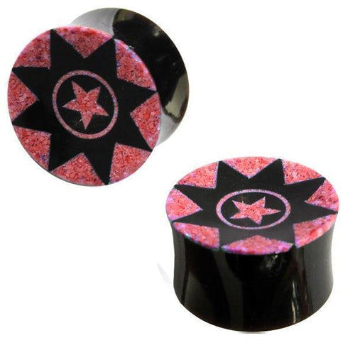 The black hand-carved Horn Plug "Sternenmuster pink" features a striking tribal star design—a large black star with a pink star inside, all set on a glittery pink background. Perfect as Buffalo Tunnel Ohrstecker.