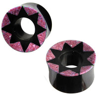 Load image into Gallery viewer, A pair of hand-carved black Horn Tunnel plugs with pink star patterns and textured details, offering a striking design for those who want the Ohrplug rosa Stern look.
