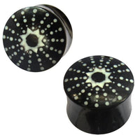 Load image into Gallery viewer, The Horn Plug schwarz weiß Stern Punkte handgeschnitzt are two black double flared plugs made from hand-carved buffalo horn, each featuring a white starburst dot pattern on the ends for a unique, tribal-inspired look.
