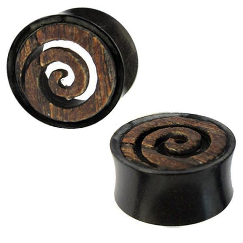 Two circular Holztunnel Spiraleninlay plugs, hand-carved from brown Eisenholz and black buffalo horn, feature a rustic spiral design inspired by Tribal Tunnel styles, blending a textured pattern with a smooth, dark background.