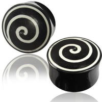 Load image into Gallery viewer, Two Horn Plug Spirale schwarz weiß Flesh Tunnel plugs, made from black Büffelhorn with white bone spiral inlays, are displayed on a reflective surface. The central spirals create a striking visual effect.
