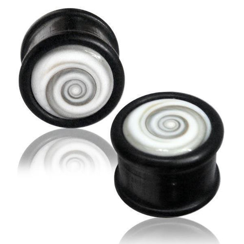 Two black cylindrical Holz Plug Shivaauge plugs with white swirl shell center designs are displayed on a white background, each with a subtle reflection beneath.