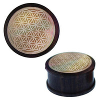Load image into Gallery viewer, The Holz Plug Perlmutt Inlay Gravur Blume des Lebens ribbed is a round, dark wooden box with a ribbed lid adorned by an intricate Flower of Life engraving and iridescent perlmutt inlay for a captivating effect.
