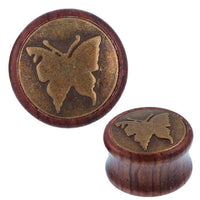 Load image into Gallery viewer, The Holz Plug Schmetterling is a round tribal tunnel expander with an antique golden brass butterfly inlay on its flat face.

