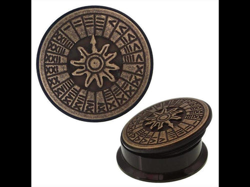 The Schraub Plug Sonnenuhr Acrylic Tunnel Expander Piercing features an antique gold brass inlay with a raised sun motif and runes, shown from two angles on a white background.