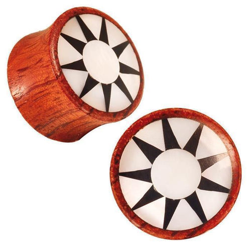 A pair of Rangas Holz Plug in dark brown wood, each with a white shell inlay and a black star design radiating from the center.