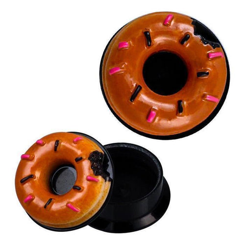 The Schraub 3D Plug Acryl Donut is a small, round, brown tunnel piercing with a 3D donut design and pink sprinkles. The open container reveals a sleek black interior, perfect for storing your Ohrschmuck.