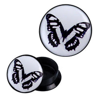 Load image into Gallery viewer, A pair of Schraub Plug Acryl Schmetterling schwarz weiß blau Piercing Ohrschmuck with black circular sides and white faces, each displaying a delicate black, white, and blue butterfly pattern. One plug stands upright, the other lies on its side.
