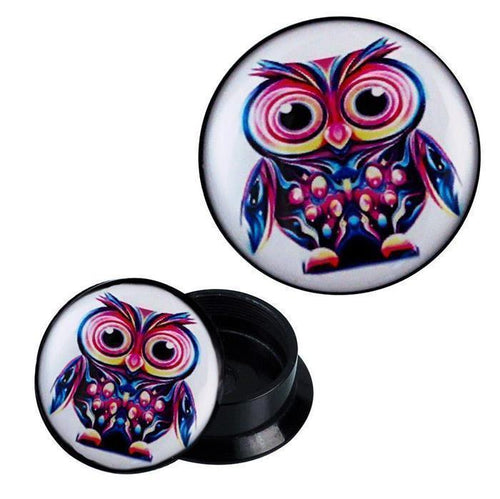 A round black Acryl Schraub Plug with a thick owl design in blue, yellow, and pink. One Piercing Ohrschmuck stands upright to show the front, while another lies on its side displaying the back.