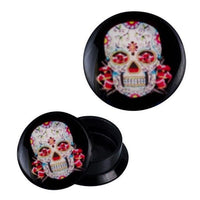 Load image into Gallery viewer, Two white and red Schraub Plug Acryl Mexican Sugar Skull Piercing Ohrschmuck, each featuring a vibrant Día de Muertos sugar skull design with floral patterns. One plug stands upright, the other lies flat, highlighting the colorful motif.
