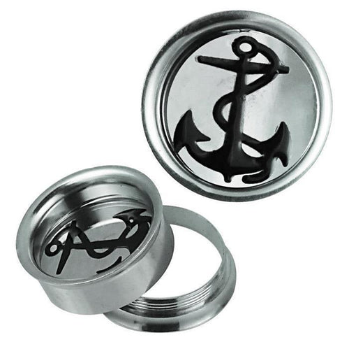 The Schraub Plug Tunnel silbern schwarz Edelstahl Anker Seil Piercing includes two round silver plugs with black anchor designs—one stands upright, while the other lies flat with its threaded back detached and placed beside it.
