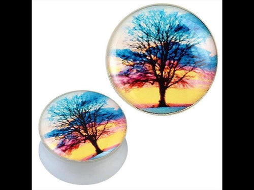 Two round white acrylic plugs feature a black tree silhouette against a colorful sunset in blue, pink, orange, and yellow. These glossy Piercing Plugs are called "Plug weiß Acryl Baum schwarz Sonnenuntergang bunt Ohrschmuck.