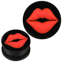 Load image into Gallery viewer, The Silikon Plug weich schwarz zeigt vorn ein auffälliges rotes Lippen Kussmund Design. Das Bild präsentiert den Piercing Ohrschmuck sowohl frontal als auch schräg – beide Ansichten des gleichen schwarzen Plugs.

