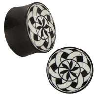 Load image into Gallery viewer, Two Plug Horn weiß Gravur schwarz Bänder Blende Sternmuster plugs feature a black and white spiral pattern with interlocking shapes on one end, creating a visually striking kaleidoscope effect.
