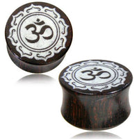 Load image into Gallery viewer, A pair of dark brown "Holz Plug Tamarinde Bone Inlay Om" plugs with an oriental carved design, featuring a white Om symbol (ॐ) at the center, bordered by an ornate pattern.
