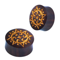 Load image into Gallery viewer, Two round, dark brown wooden plugs with gold laser engraving feature symmetrical sun, dots, and spiral patterns—highlighting ornate curved details on top. Product: Plug Holz dunkelbraun Lasergravur gold Punkte Spiralen Sonne.
