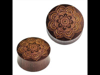 Load image into Gallery viewer, Two round, dark brown Holz Plug Mandala Blume made from Sonoholz, with golden engraved mandala designs on their flat surfaces, presented against a white background.
