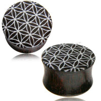 Load image into Gallery viewer, Two dark circular Holz Plug Tamarinde Bone Inlay Blume des Lebens handgeschnitzt Tribal Tunnel Expanders with a white geometric flower of life pattern are displayed on a white background, blending striking style and natural charm.
