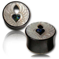 Cargar imagen en el visor de la galería, Two round black Holz Tunnel Engel Flügel Herz Arang wood plugs feature white carved wing and heart designs with blue-green Perlmutt abalone inlays at the center, displayed on a reflective white surface.

