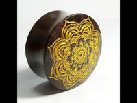 Load image into Gallery viewer, A round, dark brown "Holz Plug Mandala Blume Sonoholz" box with a golden mandala engraving on the lid is displayed at an angle on a plain white background.
