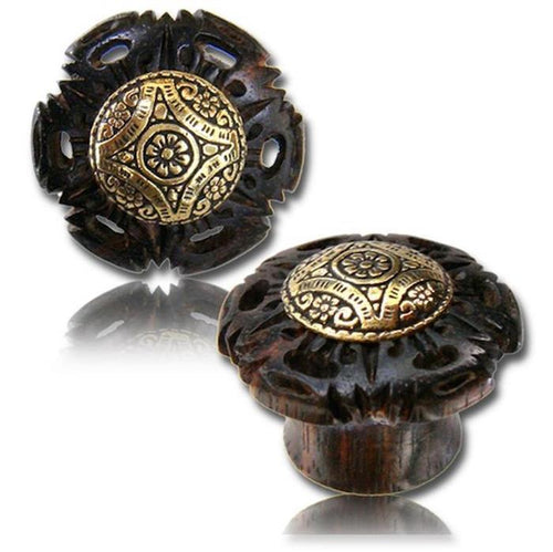 Two ornate Tamarinden Holz Plug drawer knobs in dark wood with antique golden brass inlay, featuring rhombus and floral tribal patterns—one shown from the front, the other from the side.