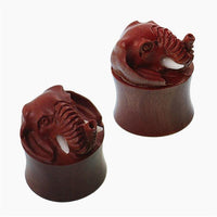 Load image into Gallery viewer, Two brown Holz Plugs featuring raised elephant head designs with bone-effect tusks are shown on a white background—these "Holz Plug braun Elefant Bone Stoßzähne plastisch Tunnel Tribal Expander Organic" provide a bold tribal look.
