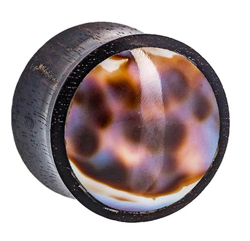 The Organic Arangholz Plug features a polished, domed shell inlay with black dots and tribal white and dark accents, reminiscent of a Muschel Lobe Piercing Plug, shown against a plain white background.
