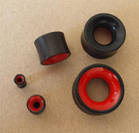 Load image into Gallery viewer, Five Flesh Plug Eisenholz Holz dunkel double flared rot Resin Inlay Ohr Piercing bushings, black with red resin interiors, are displayed on a brown surface.
