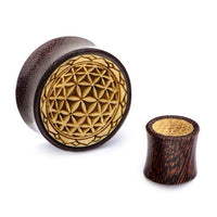 Load image into Gallery viewer, The Plug Holz Tamarinde Krokodilholz Blume des Lebens Zacken Rand features dark brown, speckled wood with a carved flower of life and textured lighter center, combining unique tamarind and crocodile wood designs.
