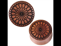 Cargar imagen en el visor de la galería, Two round Plug Sawo Holz braun with black engravings in a heart blossom tribal design. The organic tunnels feature carved, symmetrical patterns radiating from the center on a plain white background.
