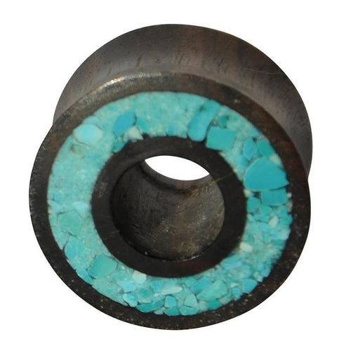 A round, black ironwood flesh tunnel with a central hole, featuring a rim inlaid with crushed turquoise—a striking accessory for fans of the Flesh Tunnel Eisenholz schwarz Rim Crushed Türkis Inlay.