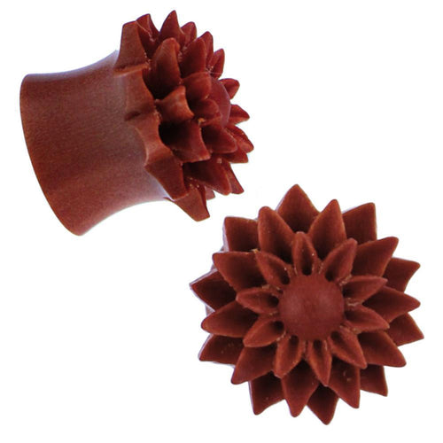 Two reddish-brown hand-carved Holzplug Sawoholz Dalie ear plugs, featuring a floral design with pointed petals and round centers, are shown from various angles against a white background.