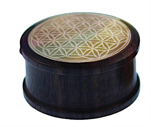 A small round wooden box named "Holz Plug Perlmutt Inlay Gravur Blume des Lebens ribbed" features an intricate Flower of Life engraving, smooth dark finish, and elegant geometric ribbed design for a refined look.