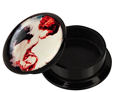 A black Schraub Plug Acryl "Engelchen sitzend" container with its lid slightly open, showing colorful abstract face art in red, white, and black—perfect for storing your Piercing Ohrschmuck.