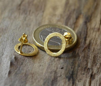 Load image into Gallery viewer, A pair of Ohrstecker Silber 925 vergoldet Creolen Ringe gebürstet is displayed on a wooden surface beside a coin for size comparison.
