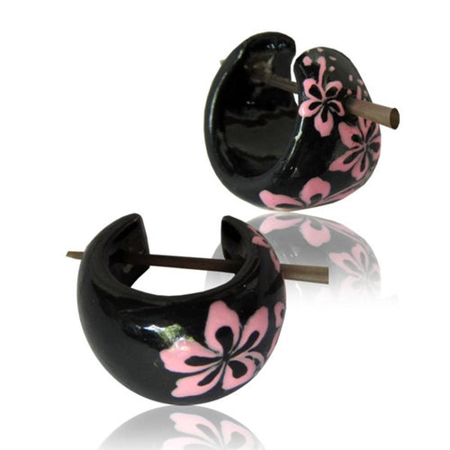 Die "Blumen Hawaii pink Holzcreolen Pin-Ohrringe" sind schwarze, handbemalte 16-mm-Holz-Pin-Creolen mit pinken Blumen und braunen Verschlüssen, auf weißem Hintergrund mit Spiegelung präsentiert.