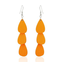 Load image into Gallery viewer, A pair of "Holzohrringe Tropfen lang 68 mm Tribal Ohrringe" featuring three stacked, teardrop-shaped orange pieces, crafted from colorful wood and stainless steel, nickel-free, hanging from silver hooks against a white background.
