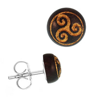 Load image into Gallery viewer, The Holzohrstecker Edelstahl Sonoholz rund 8mm gold Motive features a round dark brown wooden front with a raised gold triskelion design and a metallic post, shown from both front and side views.
