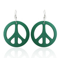 Load image into Gallery viewer, A pair of round 50 mm green Holzohrringe with cut-out Peace signs and nickel-free stainless steel hooks. The Ohrringe, "Holzohrrringe Holz rund Peace," are shown on a white background with a subtle reflection.
