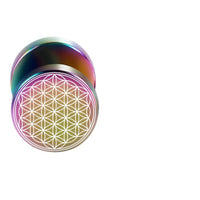 Load image into Gallery viewer, The Fake Plug Piercing Edelstahl 10mm Blume des Lebens Viking is a round, metallic plug with a rainbow sheen, engraved with the geometric Blume des Lebens pattern, shown against a white background.
