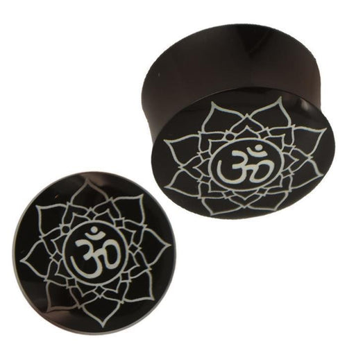 Two black "Plug Horn weiße Gravur Om Blume" piercings, each handgeschnitzt with a white mandala and Om symbol; one is shown from above, the other from the side.