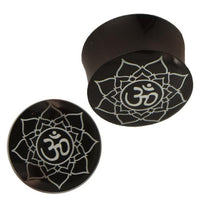 Load image into Gallery viewer, Two black "Plug Horn weiße Gravur Om Blume" piercings, each handgeschnitzt with a white mandala and Om symbol; one is shown from above, the other from the side.
