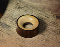 Load image into Gallery viewer, A small, round Holz Tunnel braun gelb aus Sonoholz und Teakholz, double flared mit hellem Innenbereich und dunklerem Rand, liegt auf einer Holzoberfläche – ideal als Piercing-Schmuck.
