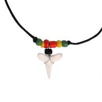 Load image into Gallery viewer, The Surferkette Haifzahn features a round surfboard design with wood and shell accents, an adjustable cord, and a shark tooth pendant for a bold beach vibe.
