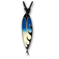 Load image into Gallery viewer, Die Surferkette Baumwolle Holz Surfbrett Halskette ist ein handbemalter Anhänger in Surfbrettform, mit Blau-Weiß-Verlauf und weißen Wellenmotiven, am schwarzen Kordelband mit Knoten über dem Anhänger.
