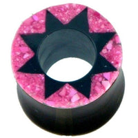Load image into Gallery viewer, The Horn Tunnel schwarz Stern Muster pink handgeschnitzt is a circular black plug with a pink textured rim and bold eight-pointed star design, making it an eye-catching addition to your Ohrplug collection.
